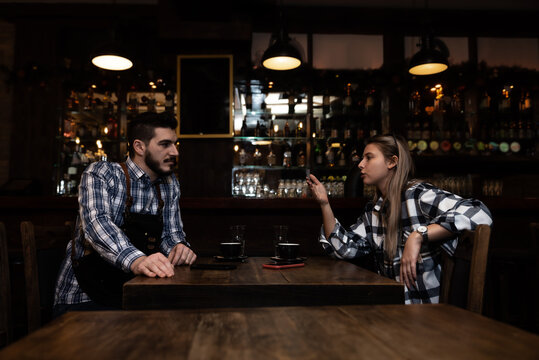 Confident owner of cafe interviewing young specialist. Manager of cafeteria or coffee shop job interview with young male bartender barista or waiter applied for work in the restaurant. Employee hiring - Powered by Adobe