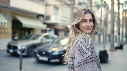 Young blonde woman smiling confident standing at street