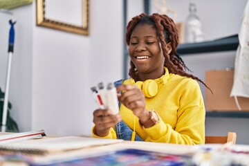African american woman artist smiling confident choosing color at art studio