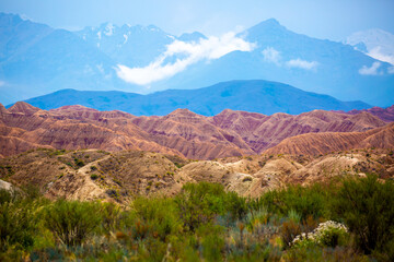 Natural unusual landscape of red rocks against the backdrop of blue mountains. The extraordinary beauty of nature is similar to the Martian landscape. Amazingly beautiful landscape.