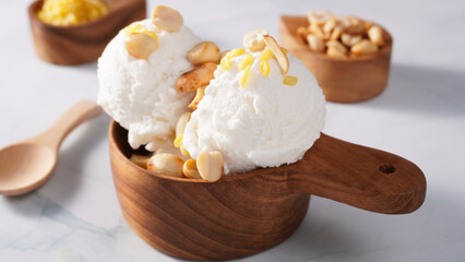 Coconut ice cream topped with roasted peanuts in a coconut shell macro shot. (spot focus)