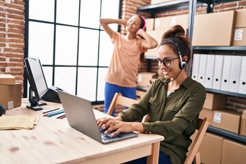 Woman and girl ecommerce call center agent working and daughter dancing at office