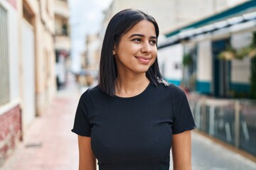 Young latin woman smiling confident standing at street