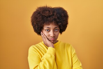 Fototapeta na wymiar Young african american woman standing over yellow background thinking looking tired and bored with depression problems with crossed arms.