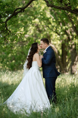 the groom and the bride are walking in the forest
