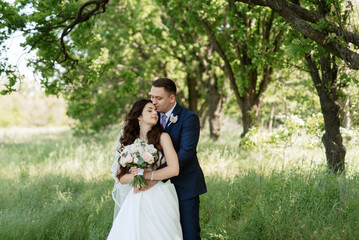 the groom and the bride are walking in the forest