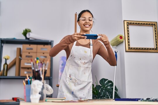 Young african american woman artist smiling confident making picture to draw at art studio