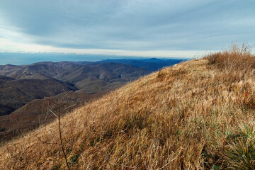 Fototapeta premium Mountain pass, mountain range. Beautiful mountain landscape. View from a great height in a picturesque place of the Caucasus. The mountain range of the Caucasus against the background of clouds. 