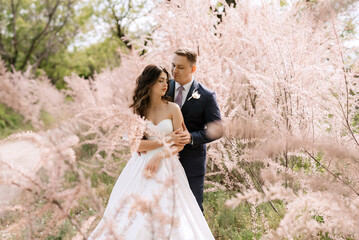 the groom and the bride are walking in the forest
