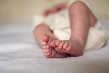 Newborn baby legs on a white blanket