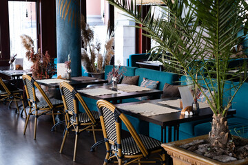 beautiful interior of the restaurant in blue tones. Tables and wicker chairs.