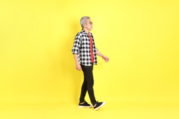 The 40s adult Asian man with casual dressed standing on the yellow background.