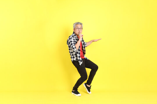 The 40s adult Asian man with casual dressed standing on the yellow background.