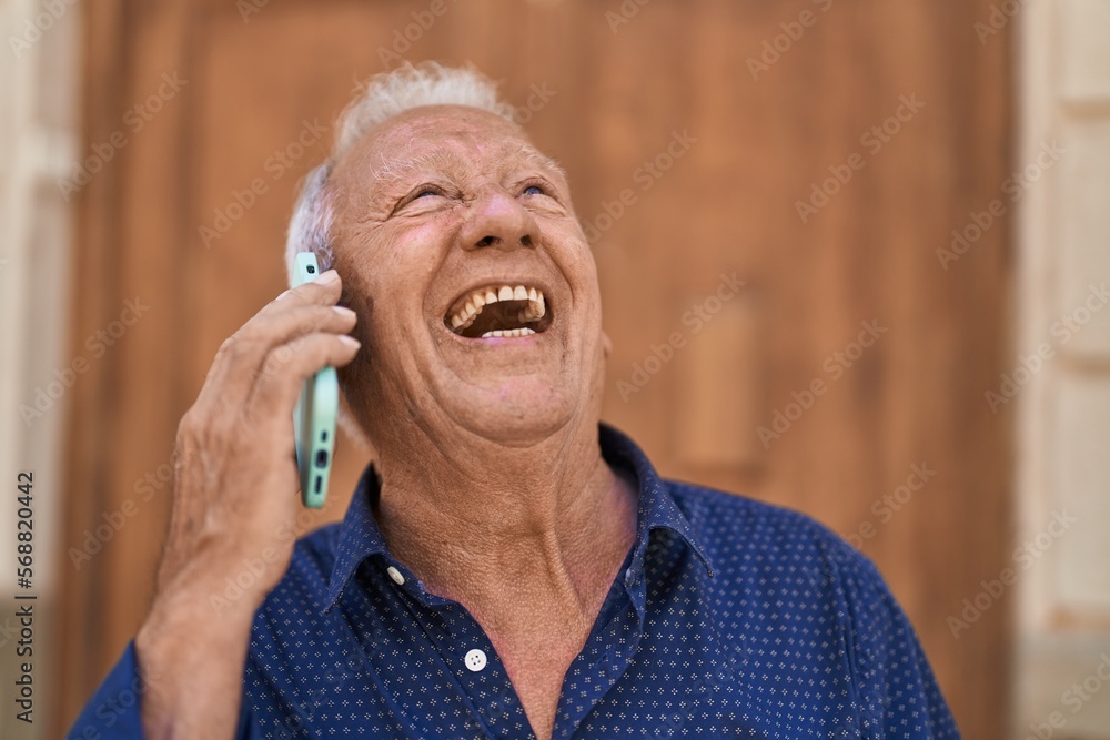 Sticker Senior grey-haired man smiling confident talking on the smartphone at street