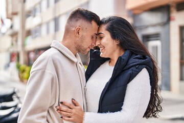 Man and woman couple hugging each other standing at street