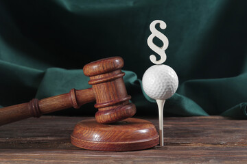 Law in golf. Judge gavel and golf ball on a wooden background. Concept of sport law and sportical...