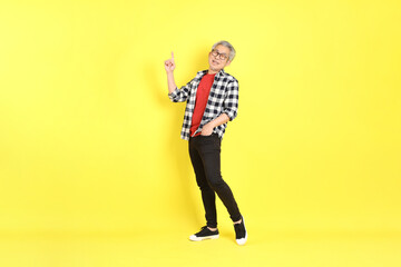 The 40s adult Asian man with casual dressed standing on the yellow background.