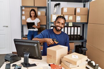 Man and woman business partners scanning package using barcode reader at storehouse