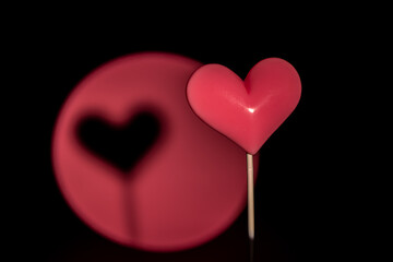 Pink Valentine's day heart shape lollipop candy on empty pastel paper background. Love Concept