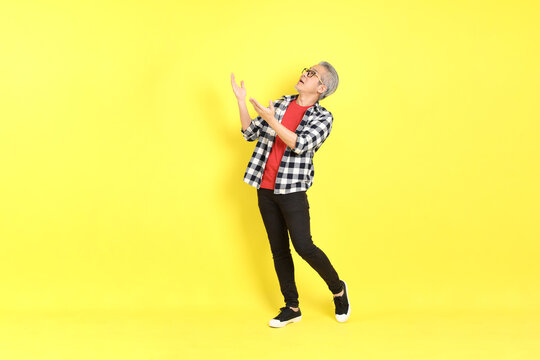 The 40s adult Asian man with casual dressed standing on the yellow background.