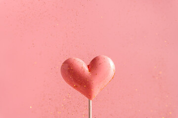 Pink Valentine's day heart shape lollipop candy on empty pastel paper background. Love Concept