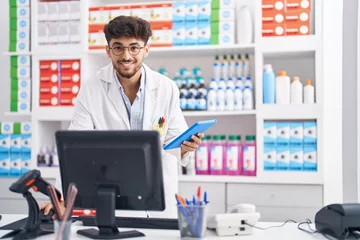 Foto op Canvas Young arab man pharmacist using computer and touchpad at pharmacy © Krakenimages.com