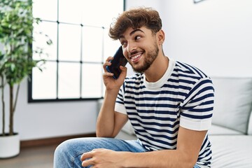 Young arab man smiling confident talking on the smartphone at home