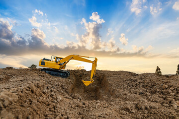 Obraz premium Crawler excavator is digging soil in the construction site with sunset backgrounds.