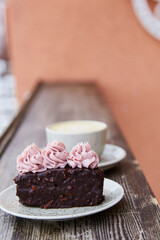 Vegan brownie cake with cup od cappuccino. Coffee with dessert outside aesthetics