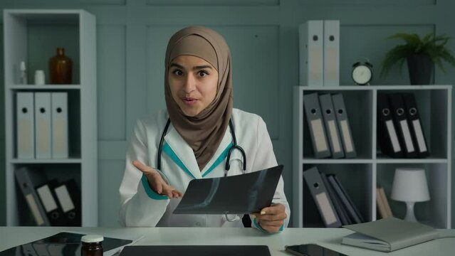 Muslim doctor woman radiologist talking with patient distant use video app explain MRI tomography result show x-ray image make virtual medical checkup online treatment say good diagnose webcam view
