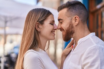 Fototapeta premium Man and woman couple smiling confident hugging each other at street