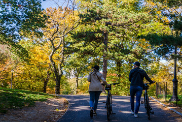 People with bicycles, Central Park, an urban park in New York City located between the Upper West and Upper East Sides of Manhattan, New York City, USA