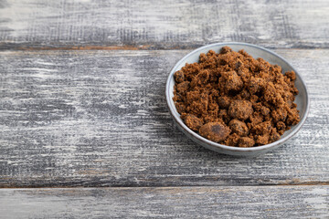 plate with unrefined cane sugar on gray wooden. side view, copy space.