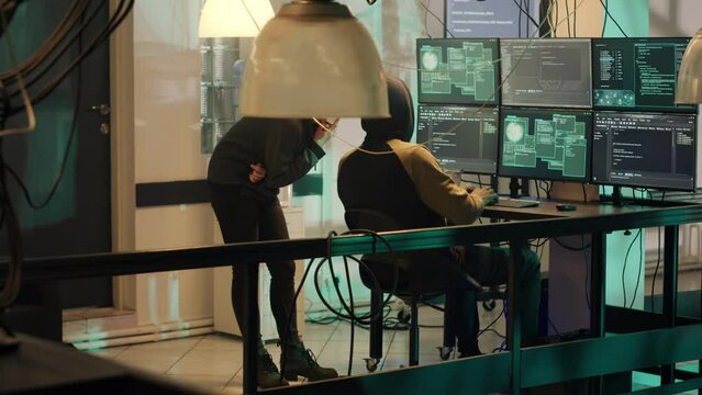 Group of thieves working with dark web to do illegal phishing on online network, trying to steal information illegally. Team of hackers breaking into server for cyberwarfare. Handheld shot.