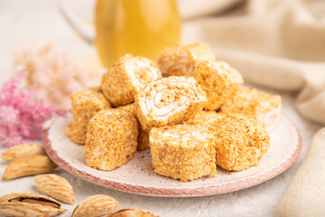Traditional turkish delight (rahat lokum) with glass of green tea on a gray concrete background,...
