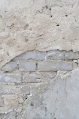 Old brick wall with peeling plaster.
