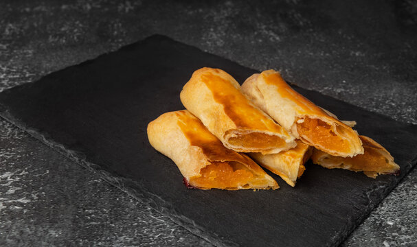 Traditional Moldovan pumpkin vertuta with pumpkin filling on a black stone board.