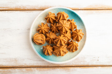 Homemade soft caramel fudge candies on white wooden, top view.