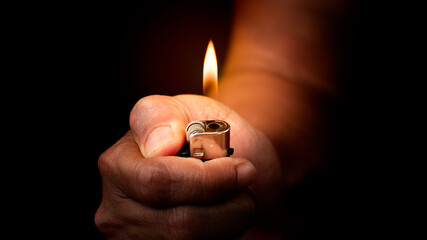  Cigarette lighter  in hand isolated on black background.