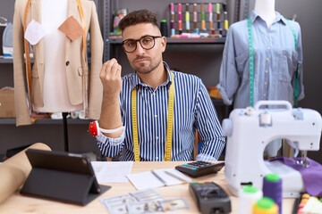 Hispanic man with beard dressmaker designer working at atelier doing italian gesture with hand and...