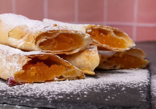 Traditional Moldovan pumpkin vertuta with pumpkin filling on a black stone board.