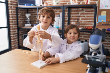 Brother and sister students smiling confident having anatomy lesson at laboratory classroom