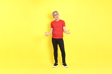 The 40s adult Asian man with casual dressed standing on the yellow background.