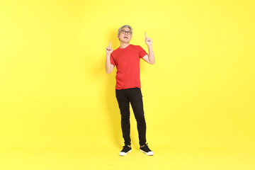 The 40s adult Asian man with casual dressed standing on the yellow background.
