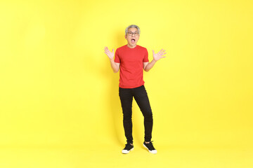 The 40s adult Asian man with casual dressed standing on the yellow background.