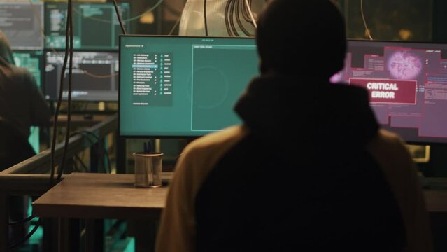Dark web spy celebrating cyber espionage success on multi monitors, feeling cheeerful about skilled hacktivism attack. Hacker doing illegal activity with pc malware, clap hands. Handheld shot.
