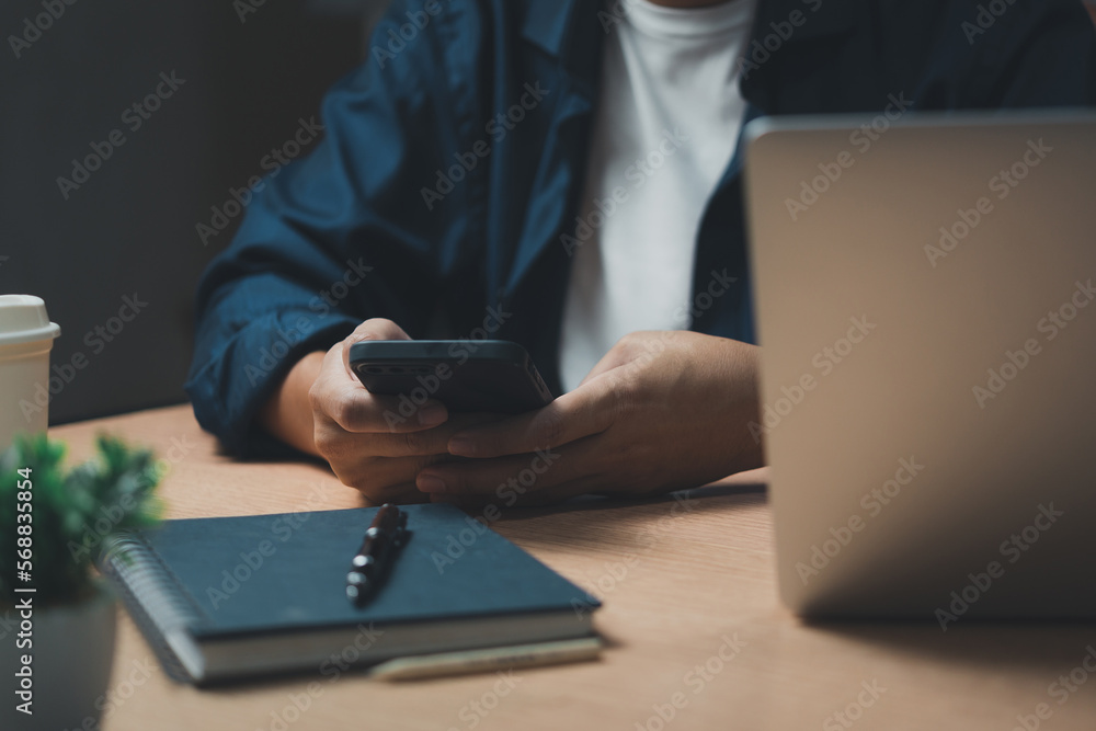 Aufkleber man using mobile smart phone and working on laptop computer.education and technology concept, studen