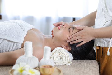 Obraz na płótnie Canvas Relaxed Asian woman receiving beauty massage in spa salon.