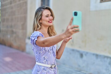 Young beautiful hispanic woman smiling confident making selfie by the smartphone at street