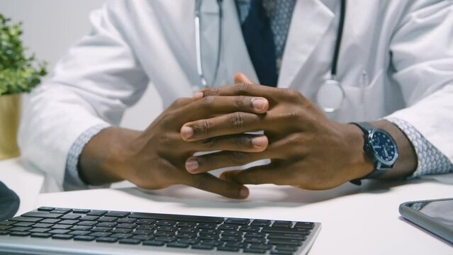 Black Stock Footage of millennial Black man doctor smiling, working, and being productive at the hospital in his office at his desk